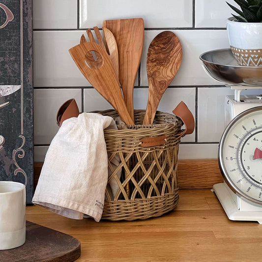 Boho tarzında dekore edilmiş bir mutfakta, el yapımı hasır ve rattan bölmeli kaşıklık; ahşap mutfak gereçleri ve doğal detaylarla birlikte şık bir şekilde sunuluyor