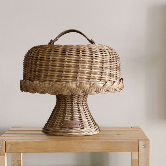 Boho tarzında dekore edilmiş bir mutfakta, el yapımı hasır ve rattan malzemeden üretilmiş kapaklı ayaklı kek ve pasta standı fanusu; doğal detaylarla şık bir şekilde sunuluyor