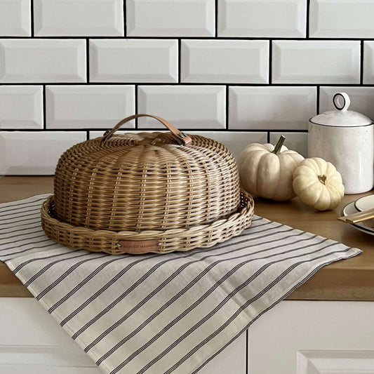 Boho tarzında dekore edilmiş bir mutfakta, el yapımı hasır ve rattan malzemeden üretilmiş kek, pasta ve ekmek fanusu; doğal seramik aksesuarlar ve sıcak detaylarla birlikte şık bir sunum için sergileniyor